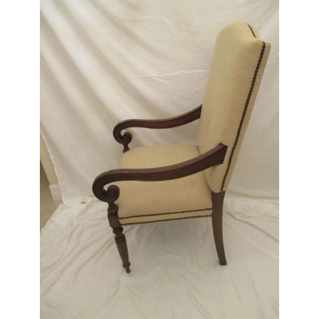 Tall upholstered club chair with arms. Chair has original upholstery in good condition with nailhead trim. Arms have signs...