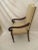 Tall upholstered club chair with arms. Chair has original upholstery in good condition with nailhead trim. Arms have signs...
