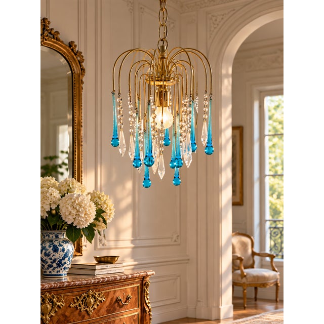 A striking vintage waterfall chandelier featuring 14 elongated turquoise-blue glass teardrops and 14 clear faceted...