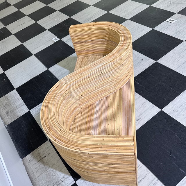 Handcrafted with exceptional skill, this striking rattan conversation chair from showcases a flowing serpentine design...