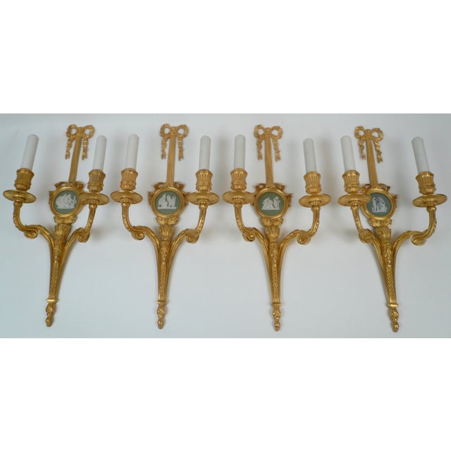 These beautiful sconces are of the finest quality, and feature Classical motifs including bowknots and acanthus leaves....