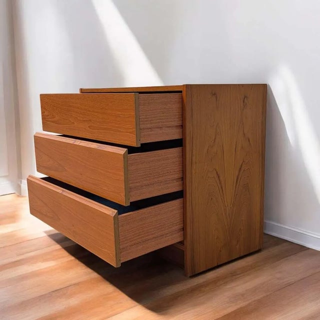 A petite 1960s teak chest with the clean geometry and warm material palette of Danish Modern design. Three broad drawers...