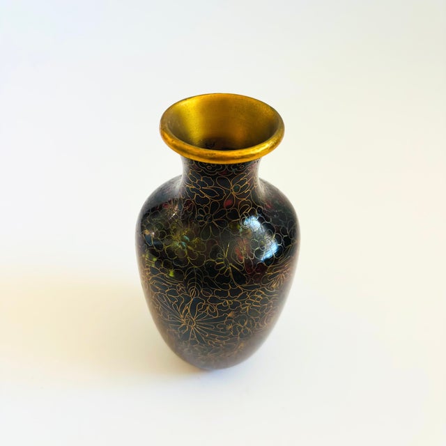 A vintage cloisonne brass vase. An intricate pattern of dark red enamels set in brass trim creates a beautiful floral...