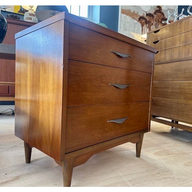Mid Century 3 Drawer Chest / dresser with curved metal pulls, an arched base with tapered legs. Walnut exterior and...