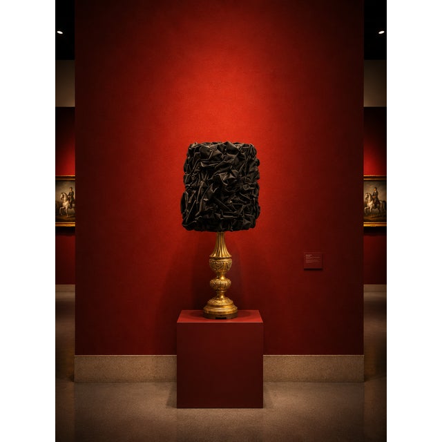 One-of-a-kind table lamp featuring an ornate antique gold-tone base with a dramatic black sculptural textured shade. The...