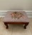 This charming mid 20th century footstool features a hand-stitched wool floral needlepoint top in soft pink with richly...
