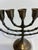 A vintage solid brass seven-branch menorah featuring elegant bamboo-inspired detailing and a warm aged patina. The...