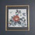Framed Porcelain Tile Featuring a Hand-Painted Floral Design By Tao Zhen. The central motif consists of two prominent...