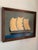A richly layered maritime scene set against a moody grey-green sky, giving the piece a quiet depth and atmospheric feel....