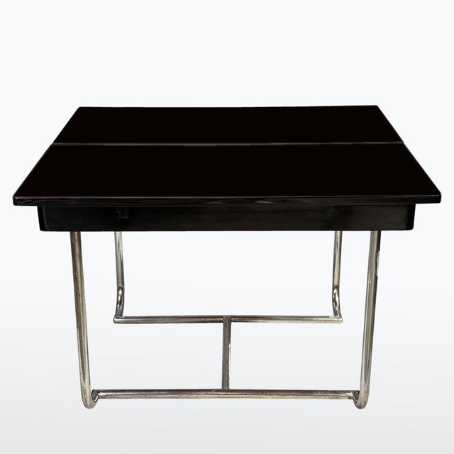 The dining table from the Functionalist period (1930s) featuring a typical chrome tubular steel frame and a black...