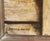 Standing in the doorway to her home, the elderly grandmother in this portrait is shown smiling at the viewer while she...