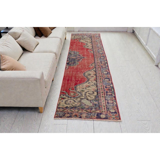 This is a vintage Turkish Oushak rug from the Mid 20th Century. The piece was hand-knotted.