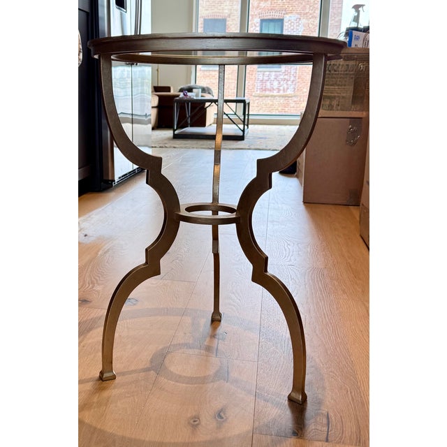 A beautifully designed Ethan Allen accent table featuring an inset glass top and sculptural metal base finished in a soft...