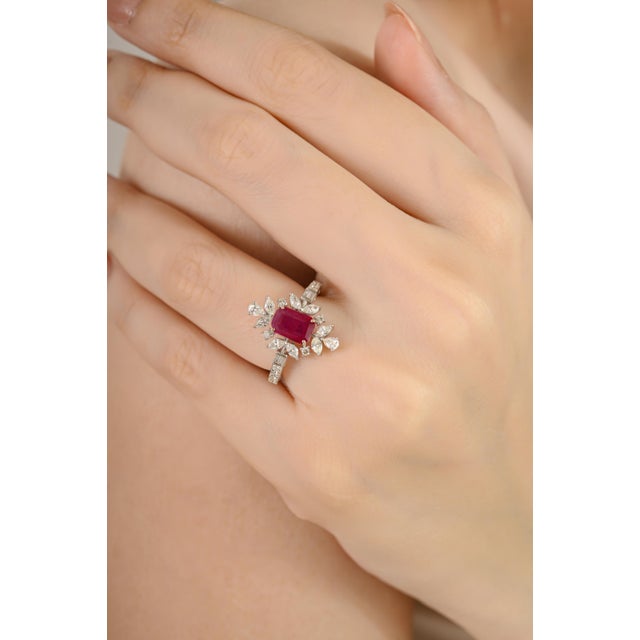 This Art Deco–inspired cocktail ring is crafted in 18K white gold, featuring a vibrant 1.08 carat emerald-cut ruby at the...