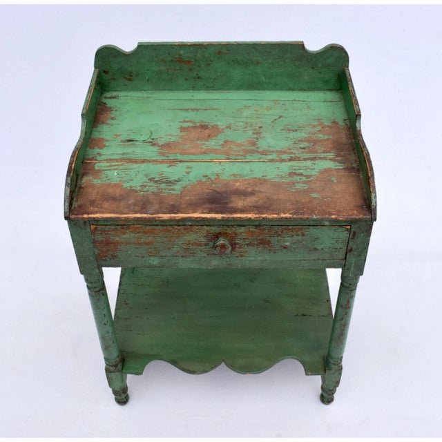 A marvelous single drawer two tier wash stand with dovetail joinery and Folk Art styling in the original green paint....