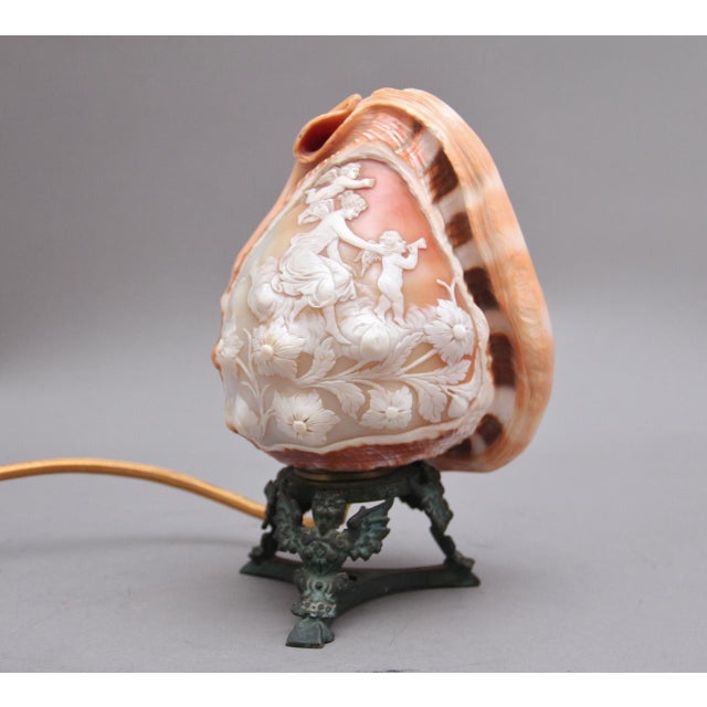 A highly decorative 19th Century Italian carved shell lamp mounted on a carved brass stand, crafted from a genuine conch...