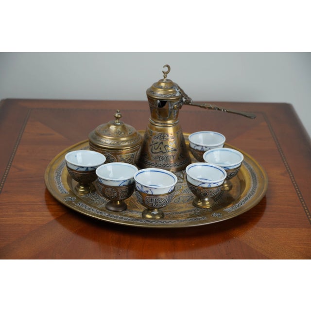 This antique Turkish coffee set reflects the artistry and tradition of Ottoman-inspired metalwork. The set includes a...