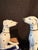 Pair- one in repose, one sitting both on royal blue cushions with gold trim. In Good condition. No chips. You can see in...