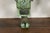 A pair of English bronze wall brackets from the 19th century with lucite tops, scrolling motifs and verdigris patina....