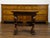 An Italian walnut small side table from the early 19th century, with lions' heads and richly carved trestle base. Created...
