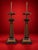 A striking pair of neoclassical-inspired table lamps featuring tall, sculptural architectural columns with richly detailed...