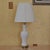 Vintage Paul Hanson table lamp featuring a glossy white porcelain baluster-form body raised on an elegant brass-tone...
