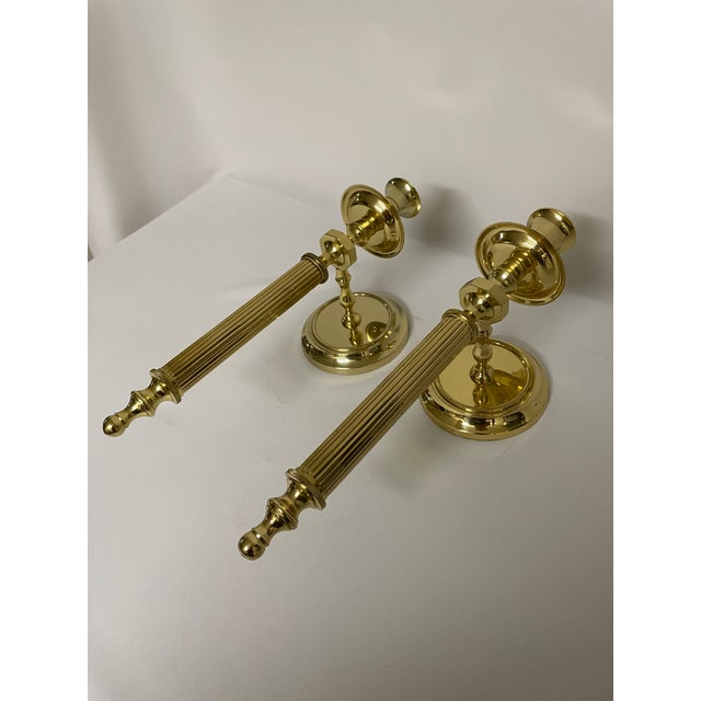 An exquisite pair of Neoclassical Style Brass Candle Sconces in the style of Maison Jansen. Circa 1980s. These high gloss...