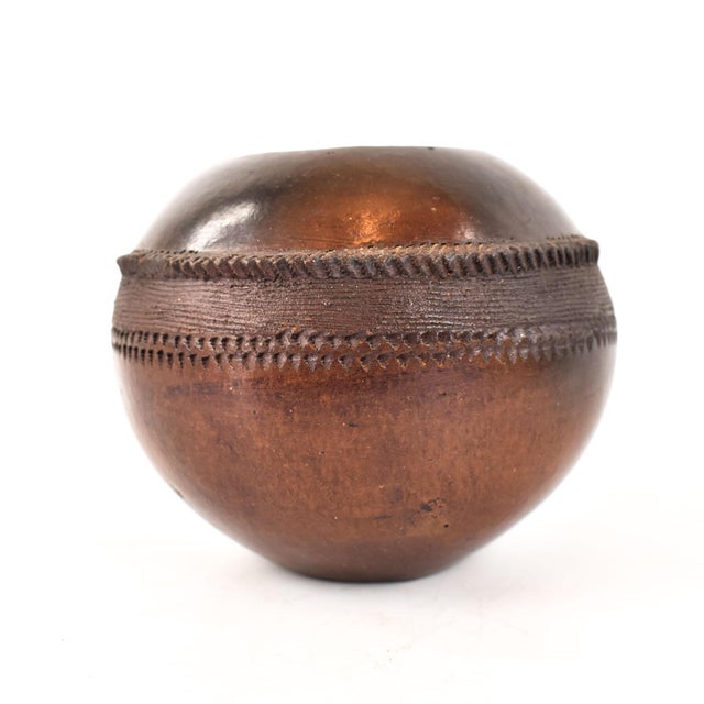 A beautiful, small clay pot from the 2010s made and signed by a Zulu artist. The exterior of the pot transitions from a...
