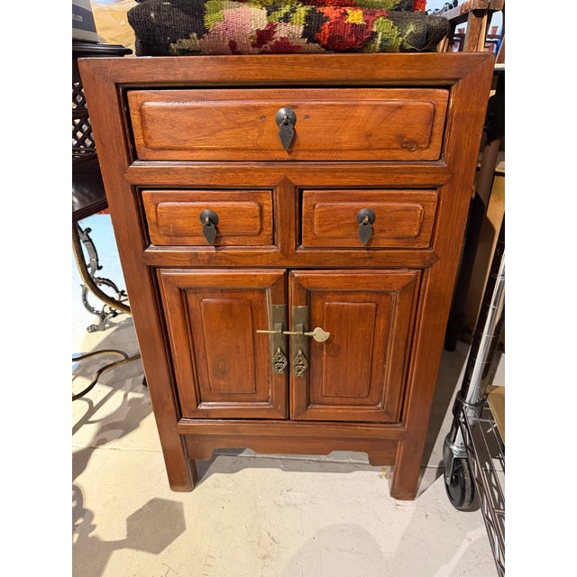 Vintage cinnabar toned Asian cabinet with three drawers and one lower cupboard. Sturdy little cabinet for the right place.