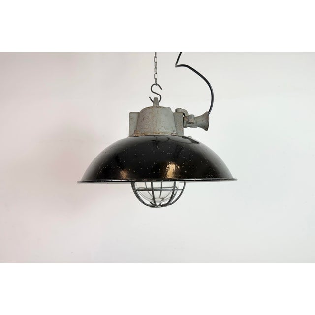 Industrial hanging lamp manufactured by Elektrosvit in former Czechoslovakia during the 1960s. It features a black enamel...