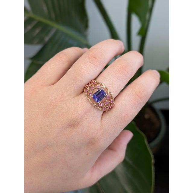 A tanzanite shines in a deep violet-blue at the centre of this solid 14K rose gold ring, accented with earth-mined...