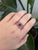 A tanzanite shines in a deep violet-blue at the centre of this solid 14K rose gold ring, accented with earth-mined...