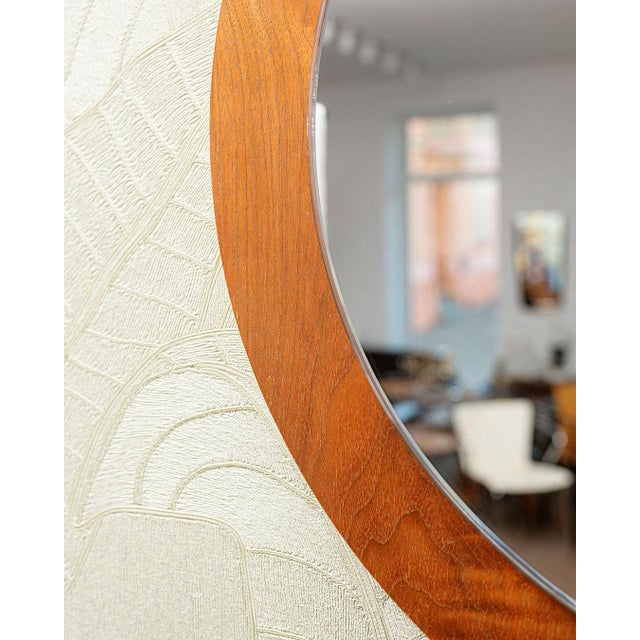 A large, round wall mirror in a teak frame, originally from Denmark. The mirror is mounted on a teak-veneered board. Very...
