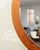 A large, round wall mirror in a teak frame, originally from Denmark. The mirror is mounted on a teak-veneered board. Very...