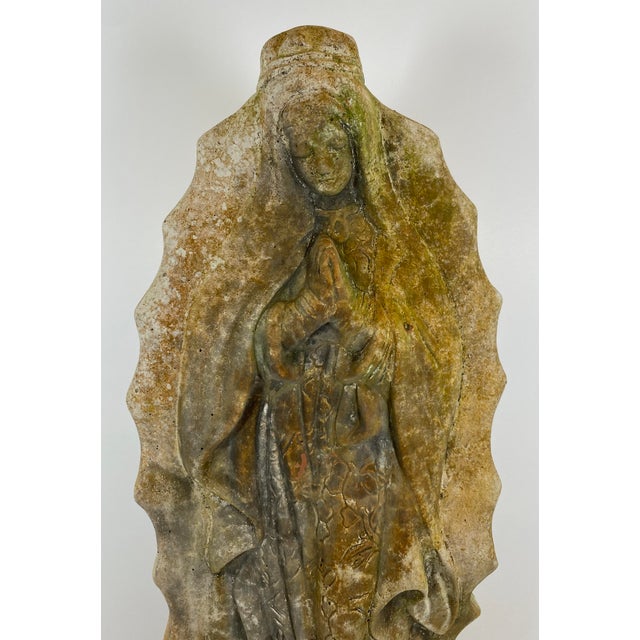 A compelling European, most likely French, devotional sculpture depicting the Madonna and Child, rendered in cast stone or...