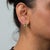 This pair of solid 14K yellow gold earrings centres two peridot stones in emerald cut, 3.36 carats together, framed by two...