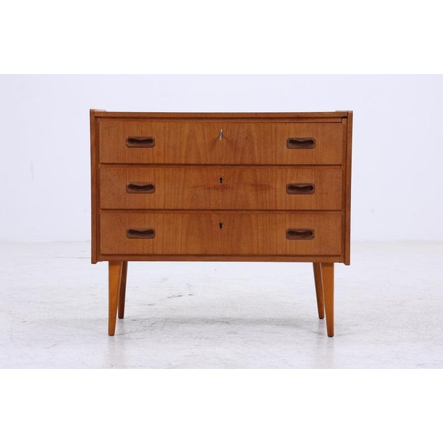 Beautiful Mid-Century Teak Chest of Drawers Made in Denmark • Three spacious drawers • Simple, geometric handle design •...