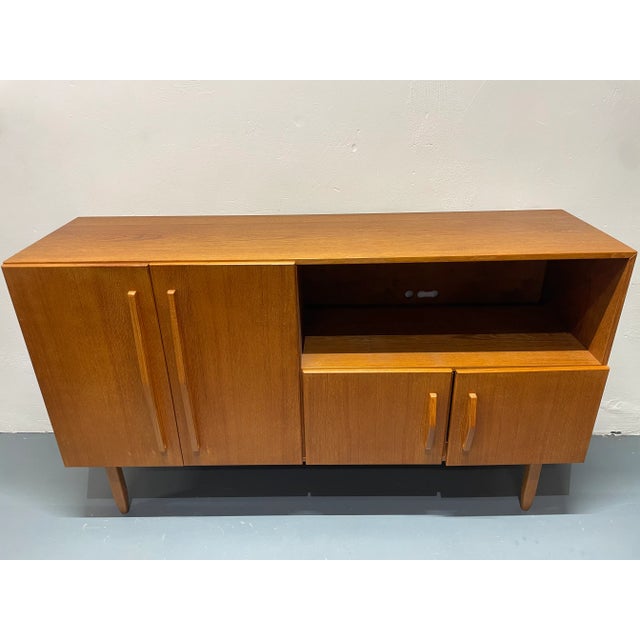 Beautiful teak highboard in good used condition. It was used as a phonograph cabinet, hence some of the holes in the back...