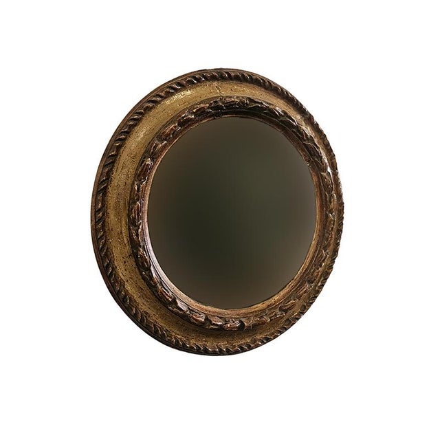 Lacquered wood mirror with a circular frame carved with plant motifs, 35 cm in diameter. Italy, 18th century.