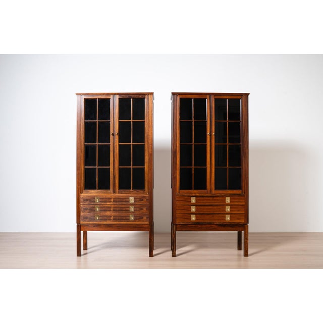 This matching pair of display cabinets comes from Norway and was manufactured by the renowned Norwegian brand Bruksbo....