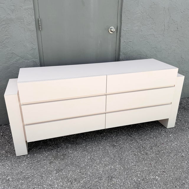 Striking 1980s Postmodern dresser featuring a clean architectural silhouette finished in light blush pink laminate. Six...