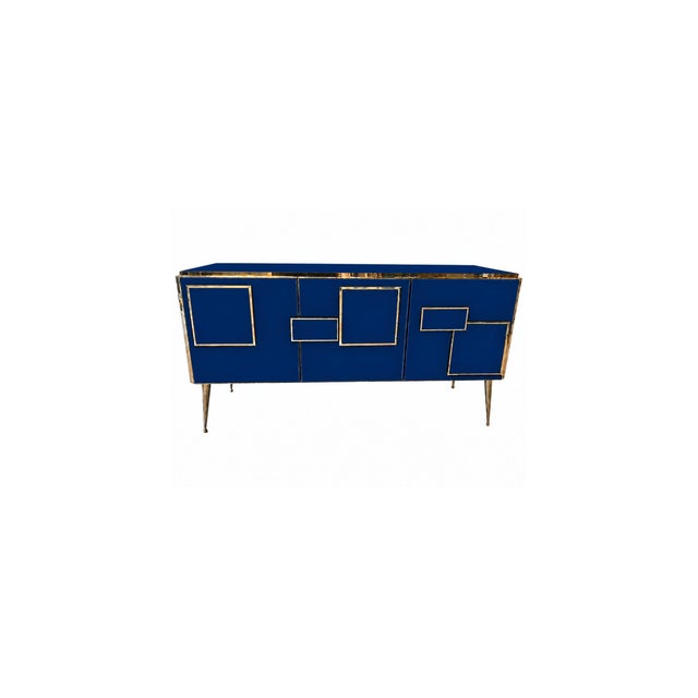 Contemporary Italian three-door sideboard handcrafted in 2026 with homogeneous deep sapphire-blue glass, polished brass...