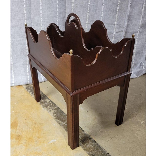 Traditional Chippendale style mahogany canterbury with a scalloped design and brass finials at each corner. Made by Hekman...
