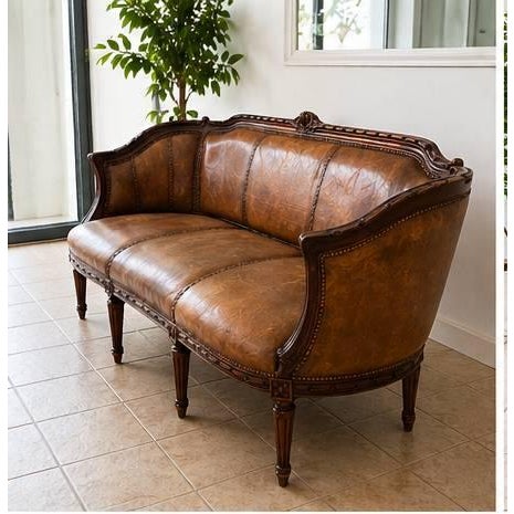 Beautiful vintage leather sofa with an elegant carved wood frame and classic French-inspired design. This is a statement...
