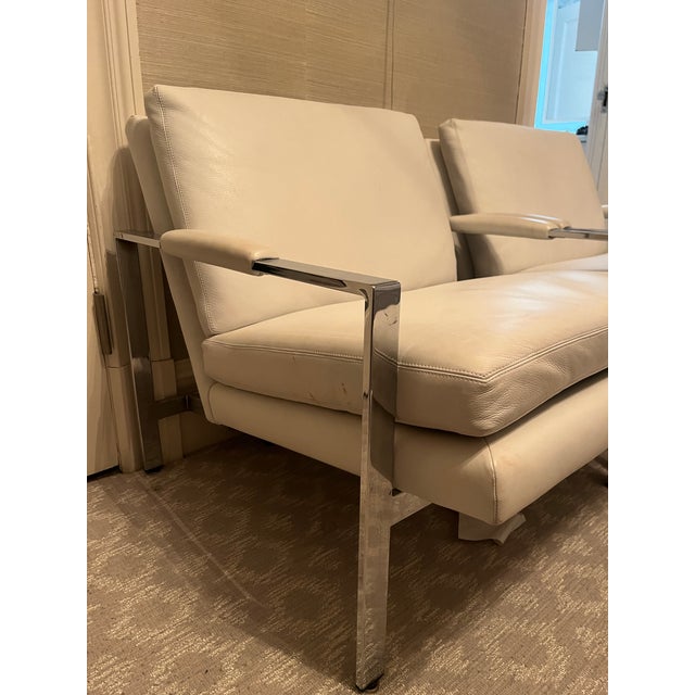 Pair of white leather, chrome structure lounge chairs designed by Milo Baughman. In good overall condition, with minor...