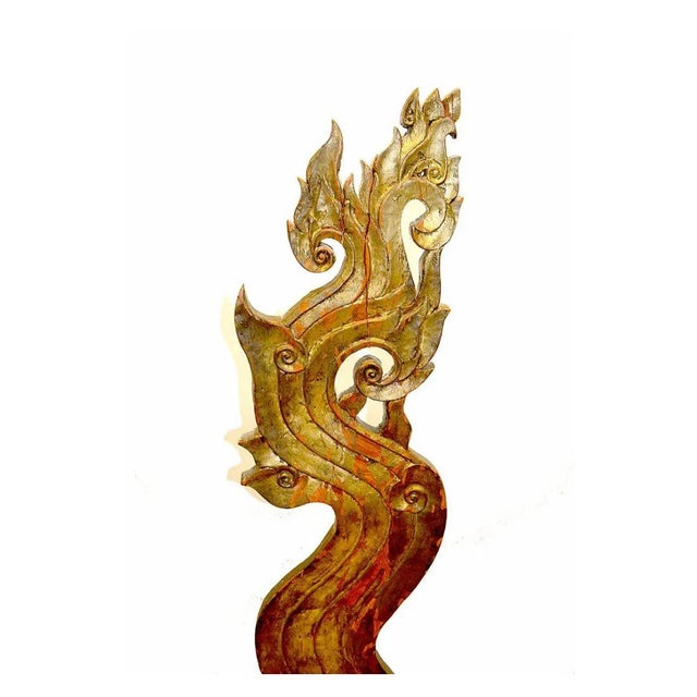 A pair of hand carved gilt wood sculptures inspired by the graceful forms of the Naga, the revered mythical serpent of...