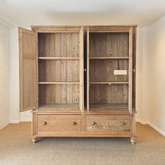 A beautiful oversized antique English pine linen press offering an incredible amount of storage while retaining the warmth...