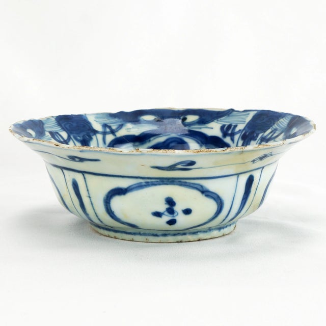 An antique Chinese bowl from the late Ming Dynasty that is hand painted and potted. The central medallion is of a bird...