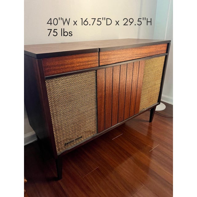 Refinished vintage stereo console featuring warm walnut-toned wood, original woven speaker fronts, and clean mid century...