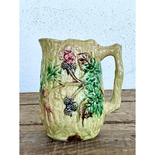 Discover the rustic elegance of this vintage English Majolica pitcher, a stunning example of traditional ceramic artistry....